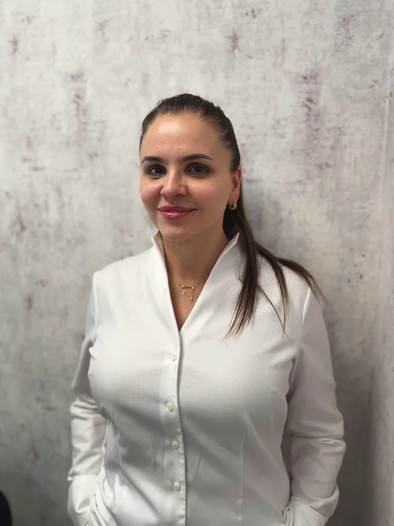Doctor-medic Gabriela Bankos in weißer Bluse, lächelnd